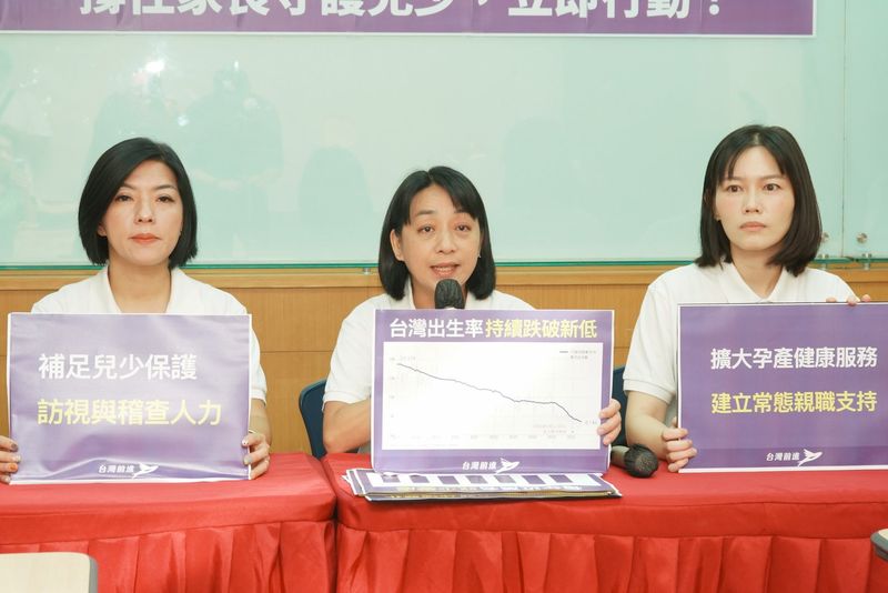兒少安全共同政見記者會，三位出席者並坐，中間者發言並持「台灣出生率持續跌破新低」圖表手板，兩側為「補足兒少保護 訪視與稽查人力」「擴大孕產健康服務 建立常態親職支持」手板