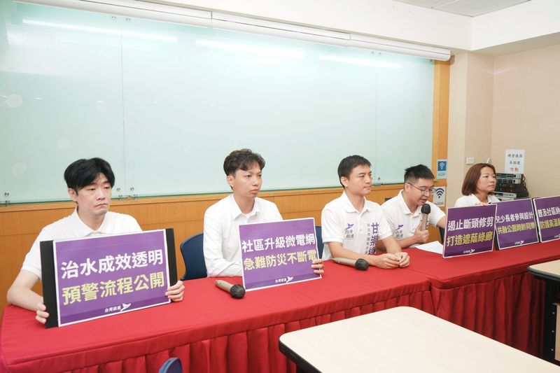 環境永續共同政見記者會，五位出席者坐在桌後，桌前有「治水成效透明 預警流程公開」「社區升級微電網 急難防災不斷電」「遏止斷頭修剪 打造遮蔭綠廊」等手板