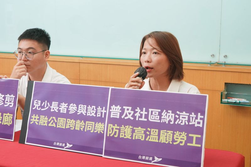 環境永續共同政見記者會，出席者持麥克風發言，前方是「兒少長者參與設計 共融公園跨齡同樂」「普及社區納涼站 防護高溫顧勞工」手板