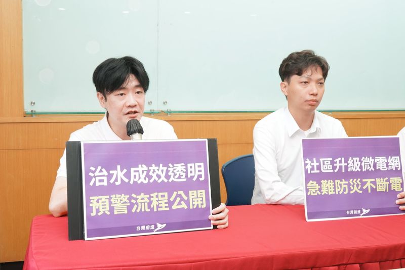 環境永續共同政見記者會，出席者手持「治水成效透明 預警流程公開」手板發言，旁邊是「社區升級微電網 急難防災不斷電」手板