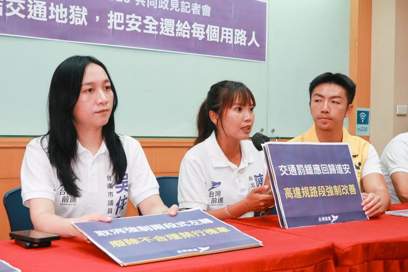 交通安全共同政見記者會，出席者發言，前方是「交通罰鍰應回歸道安 高違規路段強制改善」手板，桌上另有「取消強制兩段式左轉 廢除不合理禁行機車」手板